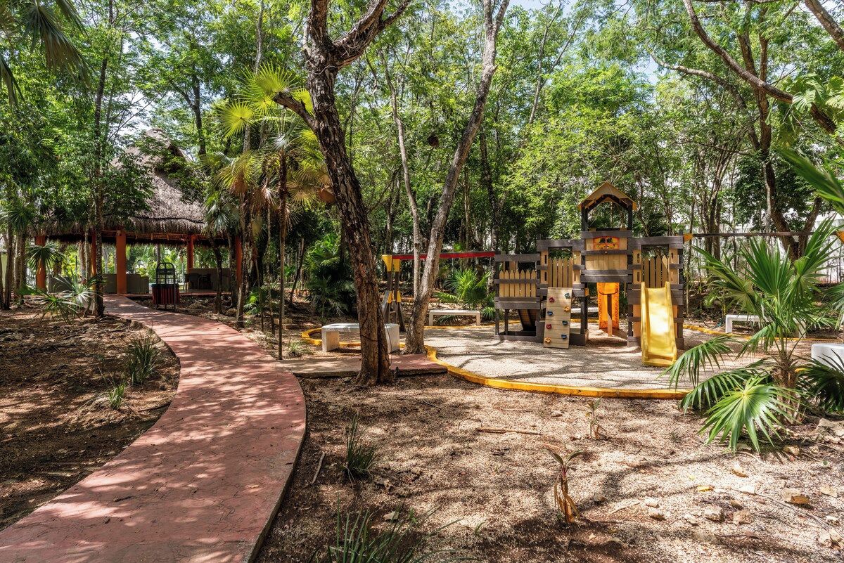 A garden with a wooden structure, a paved walkway, and various trees.