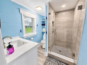 Een badkamer met een douche, wastafel en toilet.