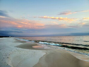 Ein Strand mit weitem Sandstrand und sanften Wellen.