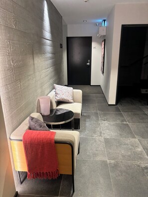 A modern interior with a sofa, a small round table, and a red throw blanket. - Spacious Accessible CBD Apartment, metres from new stadium, free carpark onsite (Christchurch)