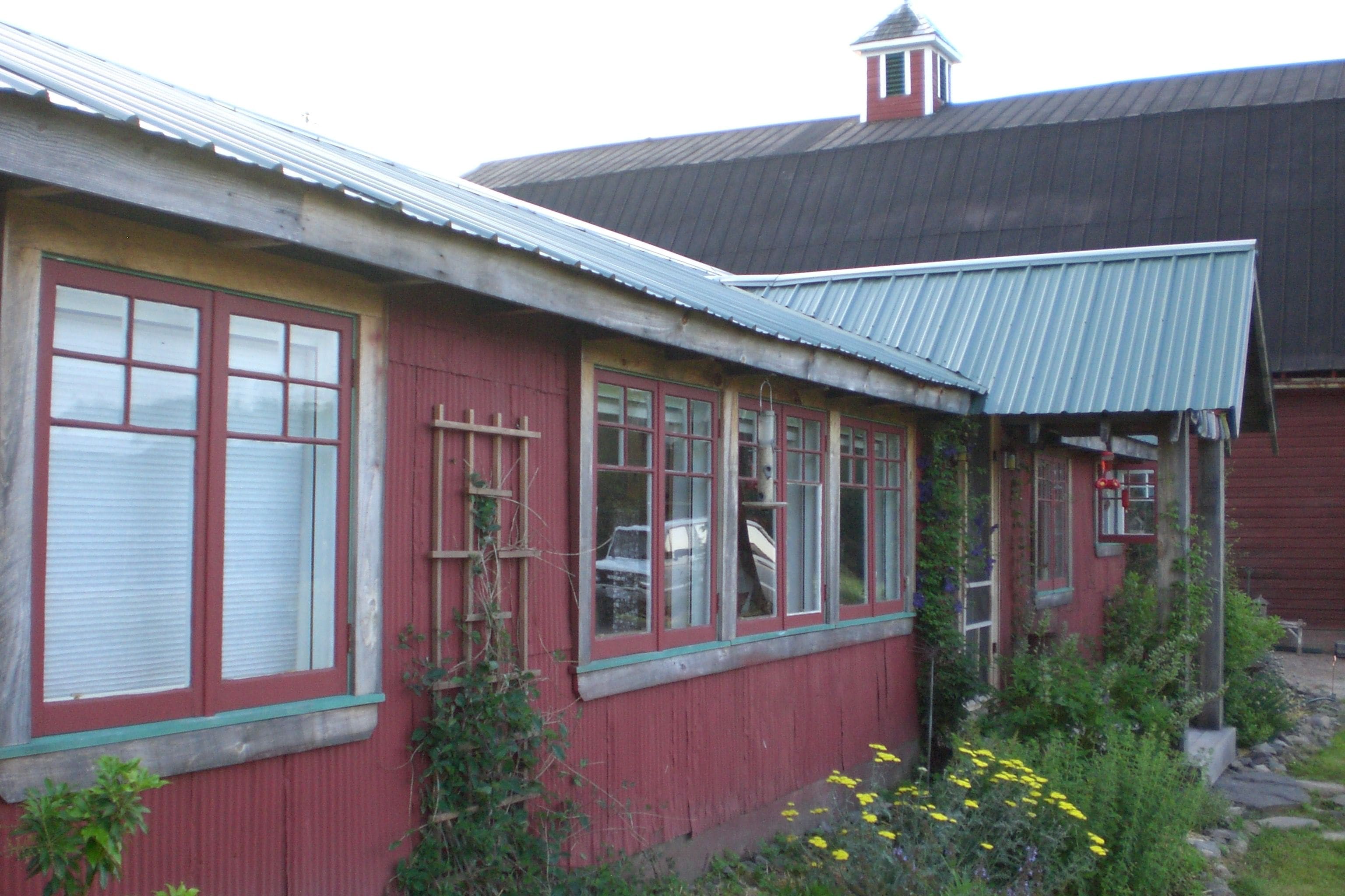 Un bâtiment rouge avec de nombreuses fenêtres et un toit en métal.