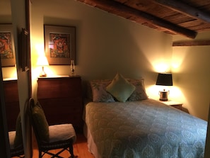 A bedroom with a bed, two bedside lamps, a chair, a dresser, and a painting on the wall. - 4-bedroom farmhouse in beautiful Hurleyville with AC comfort (Hurleyville)