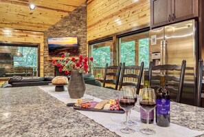 A kitchen with a granite countertop, a stone wall, and a large window. - 2 King Ensuites on first level | Private with easy access | Outdoor Fireplace | Hot Tub | Game Room (Sevierville)