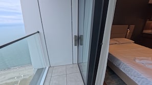 Una habitación de hotel con balcón, cama y puerta con manija.