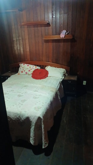 A wooden-paneled room with a bed, a shelf, and a wall socket. - House in Saquarema, spacious with games room and gourmet area!!! (Saquarema)