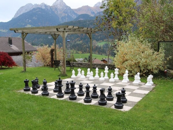 A chessboard set up outdoors with mountains in the background.