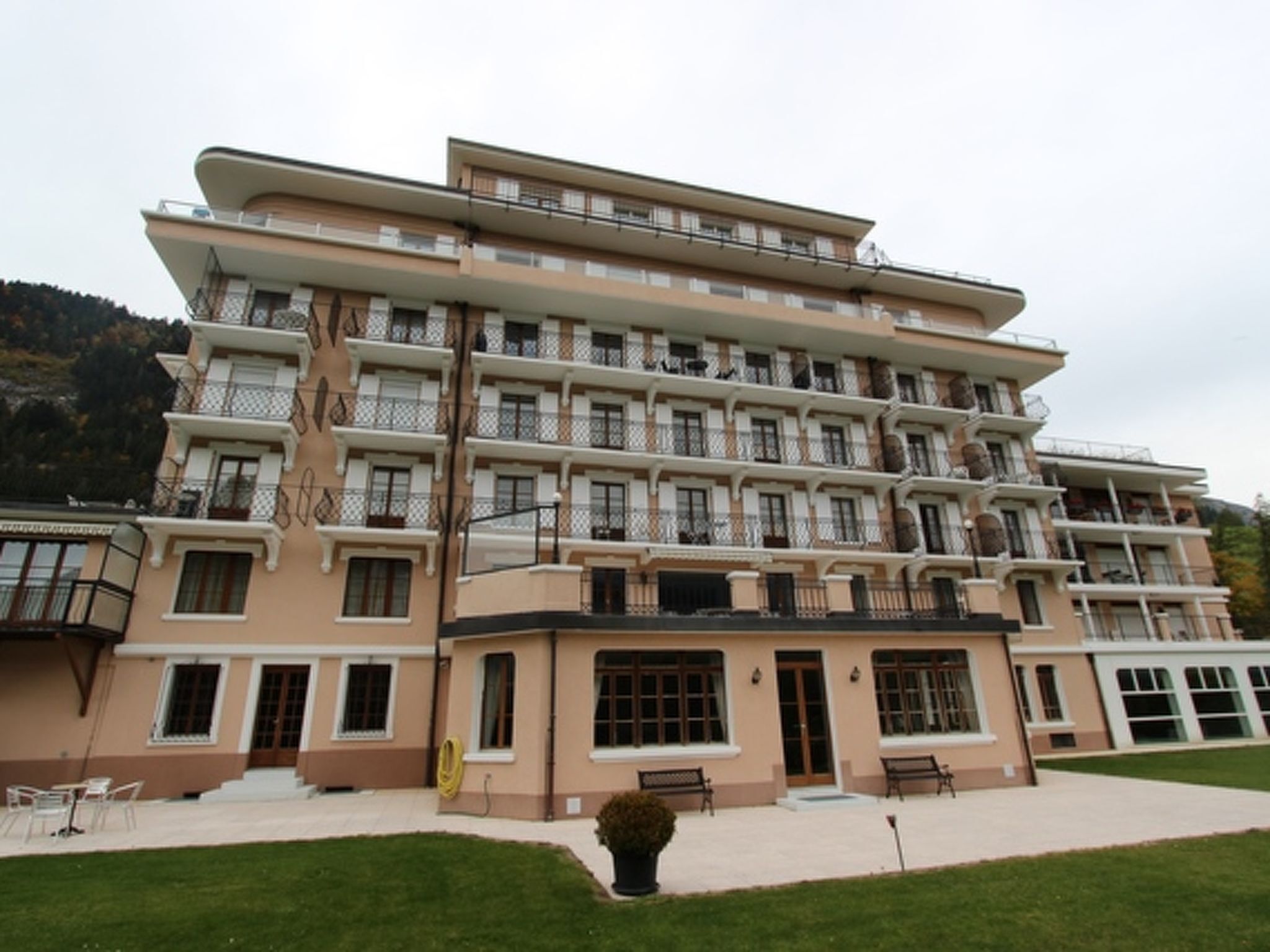 Ein mehrstöckiges Hotel mit einheitlicher Fassade, Balkonen und einer gepflegten Rasenfläche.