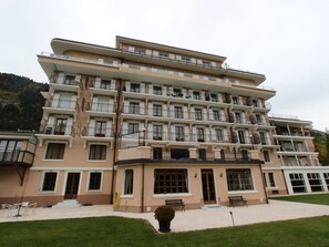 Ein mehrstöckiges Hotel mit einheitlicher Fassade, Balkonen und einer gepflegten Rasenfläche.