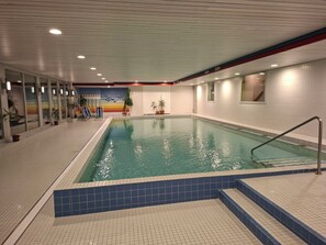 An indoor swimming pool with clear water, tiled walls, and a tiled floor. - Carmen's Oase, (Pany), by Interhome (Pany)
