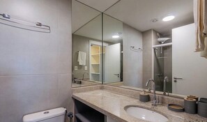 A modern bathroom with a large mirror, two sinks, a shower, and a toilet. - Studio w/ Balcony & Sea View in Condo. Aru1017 (Salvador)