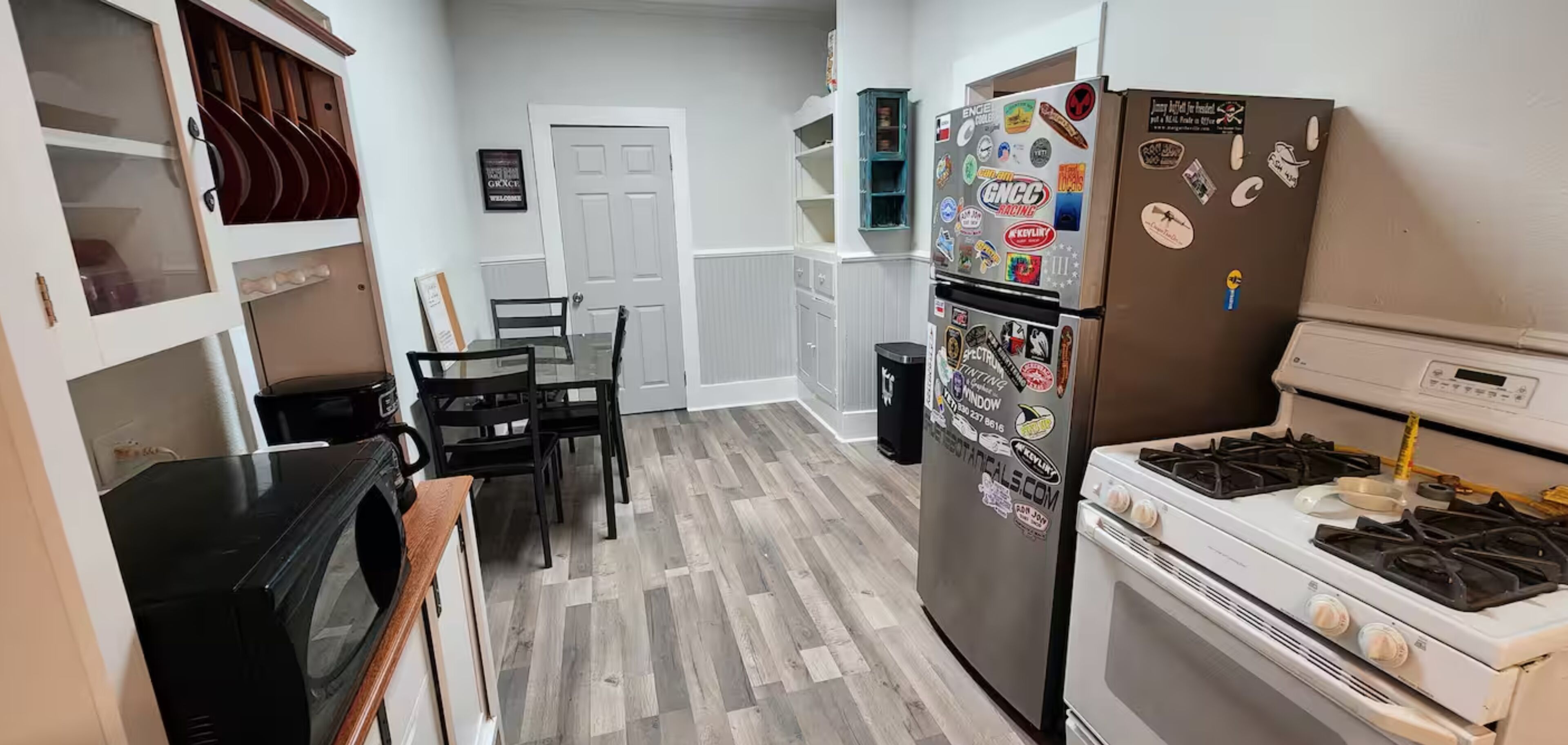 A kitchen with a refrigerator, stove, and dining table.