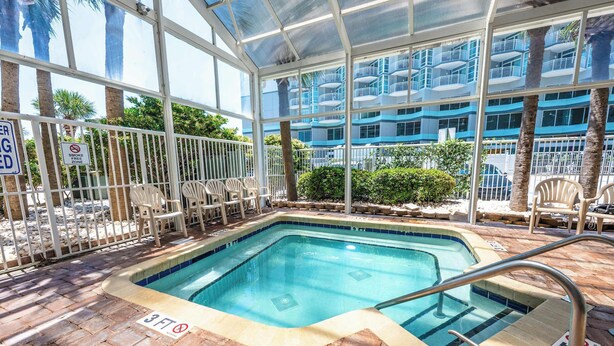 A pool area with a glass enclosure, a sign indicating a 3ft depth limit, and a no-smoking zone sign. - Amazing Oceanfront View Unit with Pool Access (Myrtle Beach)