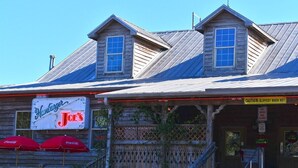A wooden building with a sign for 'Hankburger Joe's' and a caution sign for a slippery floor. - Amazing Oceanfront View Unit with Pool Access (Myrtle Beach)