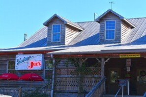 A wooden building with a sign for 'Hankburger Joe's' and a caution sign for a slippery floor. - Amazing Oceanfront View Unit with Pool Access (Myrtle Beach)