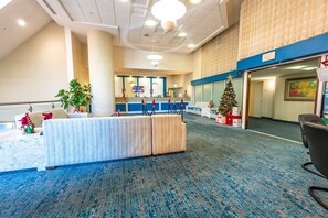 A hotel lobby with a reception desk, a Christmas tree, and a seating area. - Amazing Oceanfront View Unit with Pool Access (Myrtle Beach)