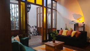 Un saló tranquil amb un sofà, una taula de cafè amb una planta i una bicicleta al fons.