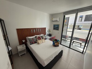 Ein modernes Schlafzimmer mit Bett, Nachttisch und Blick durch eine Schiebetür.