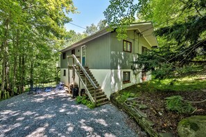 A two-story house with a gravel driveway and a wooden staircase leading to the entrance. - Delightful 6-bedroom house in charming Hensonville perfect for families (Hensonville)