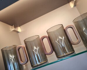 A row of clear glass mugs with wooden handles on a shelf. - Boutique Luxury Luton | King Bed | Sleeps 4 | Near Airport & Station (Luton)