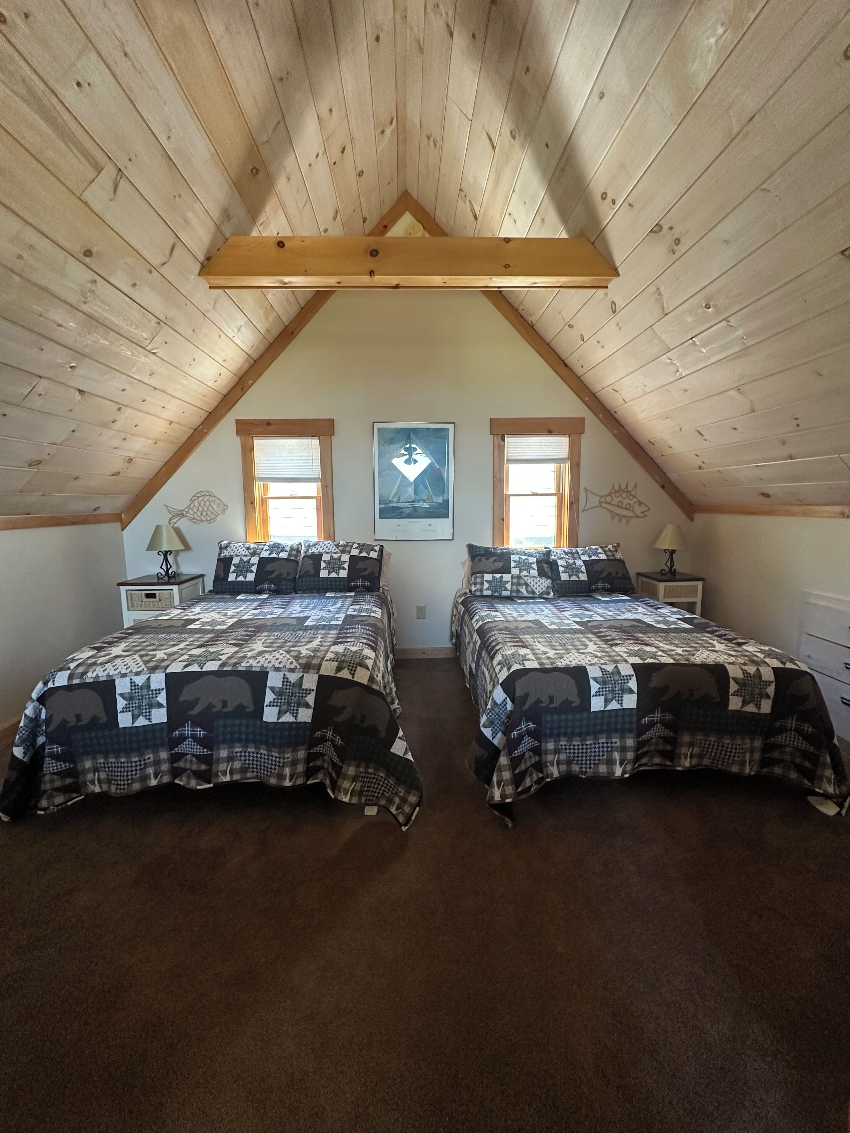 A bedroom with two beds, wooden ceiling beams, a fish wall decoration, and a framed picture on the wall.
