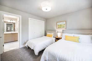 A hotel room with two beds, a wardrobe, a bathroom, and a painting on the wall. - Spacious Kirkland Home Near Microsoft & Google (Kirkland)