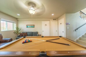 A pool table with balls and cues, a sofa, a plant, and a staircase. - The Pearl · Backyard, Hot Tub & Park Next Door (Mesa)