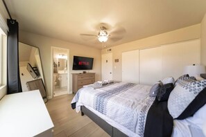 A bedroom with a bed, a TV, a wardrobe, and a desk. - The Pearl · Backyard, Hot Tub & Park Next Door (Mesa)