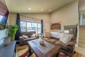 A living room with two sofas, a coffee table, and a painting on the wall. - The Pearl · Backyard, Hot Tub & Park Next Door (Mesa)
