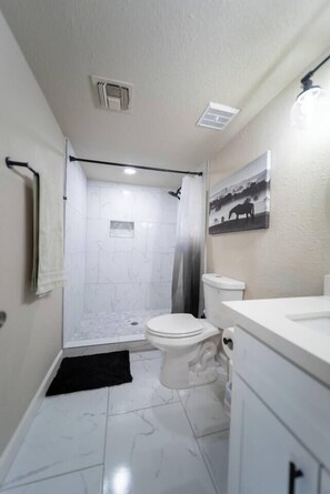 A bathroom with a shower, toilet, and sink. - The Pearl · Backyard, Hot Tub & Park Next Door (Mesa)