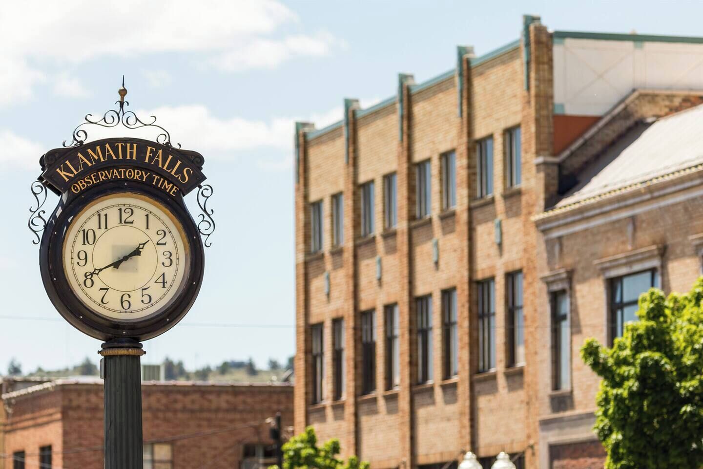 A clock with 'Klamath Falls Observatory Time' on a building facade.