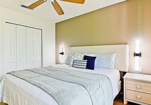 A bedroom with a bed, bedside tables, a wardrobe, and a ceiling fan. - Spacious 3-Bedroom TH Disney (Kissimmee)