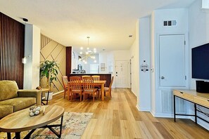 A modern living room with a sofa, coffee table, and dining area. - Spacious 3-Bedroom TH Disney (Kissimmee)