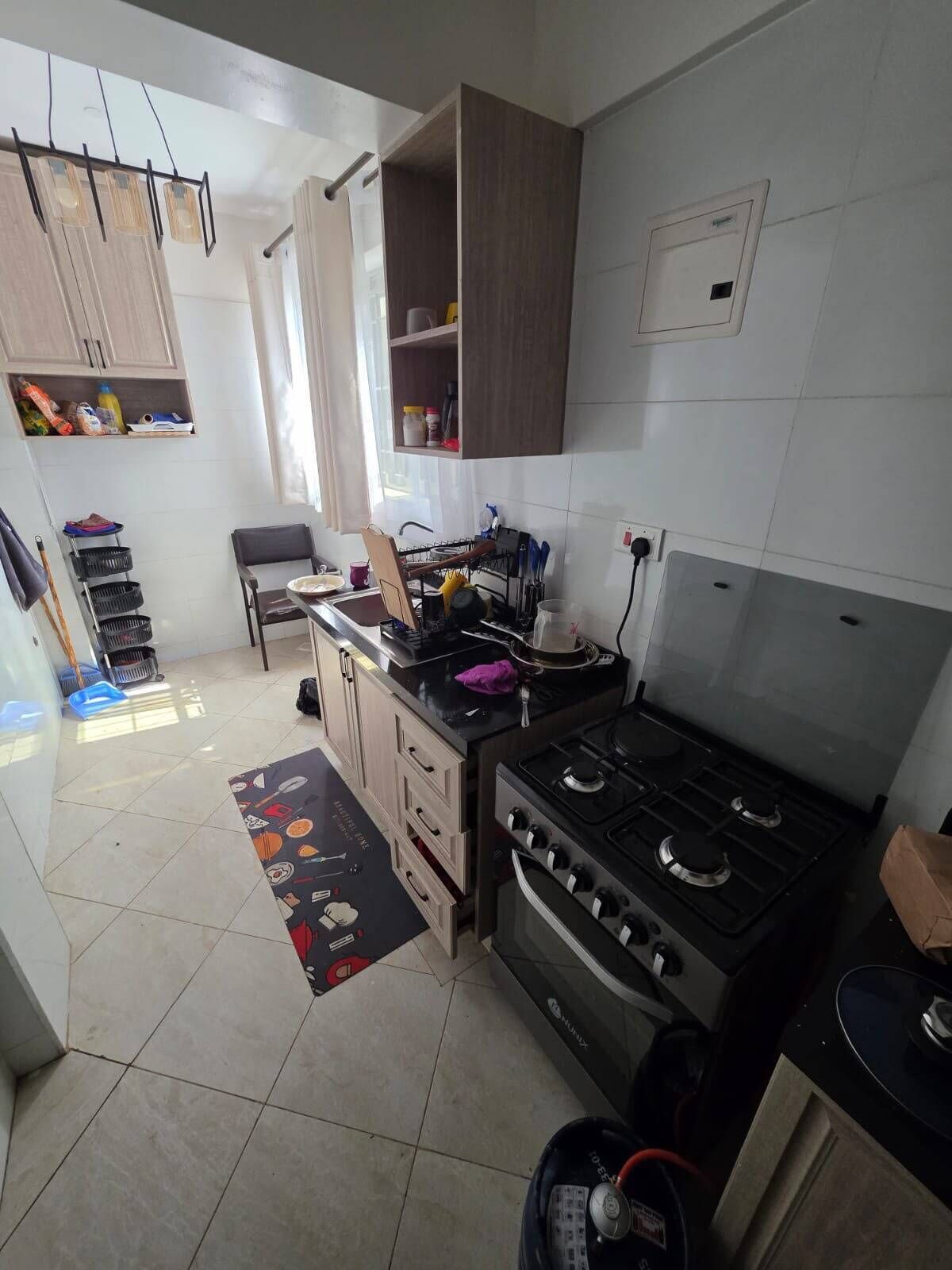 A kitchen with a stove, cabinets, and a sink.