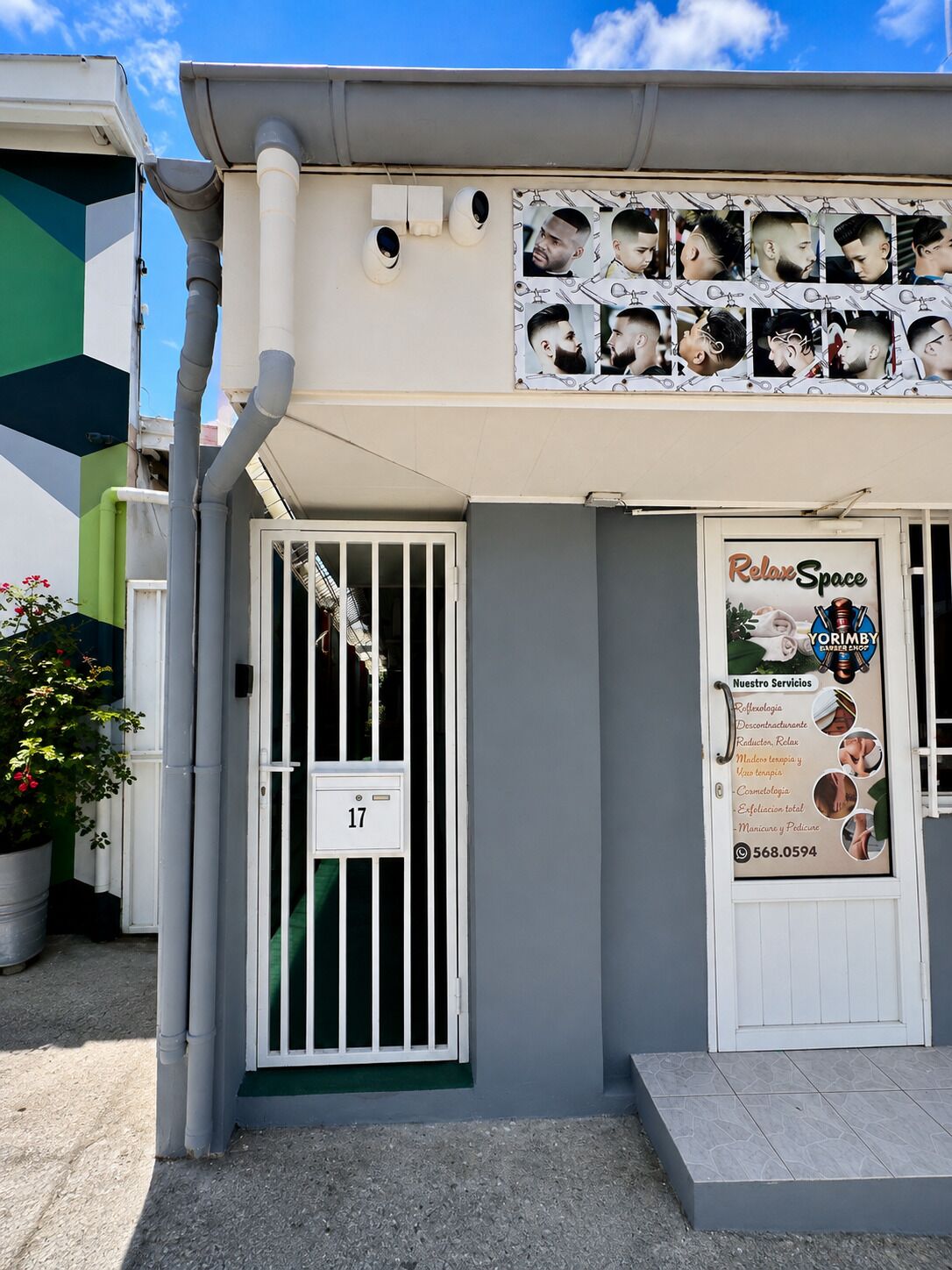 A building with a white door labeled '17' and a signboard advertising 'RelaxSpace' with services like 'Roflexologia' and 'Manicure y Pedicure'.