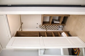 A compact room with a built-in bed, wooden storage compartments, and a small seating area. - Lovely Studio In Charming Oranjestad (Oranjestad)