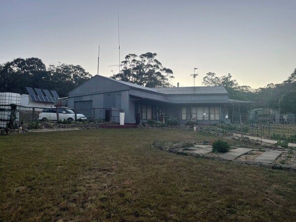 A residential property with a large house, a garage, and a car parked outside.