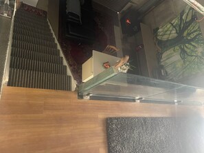 Een trap met een leuning, een houten vloer en een glazen balustrade.