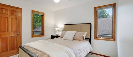 A bedroom with a bed, a nightstand, a lamp, and a ceiling fan.