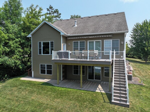 A two-story house with a balcony and a covered patio area.