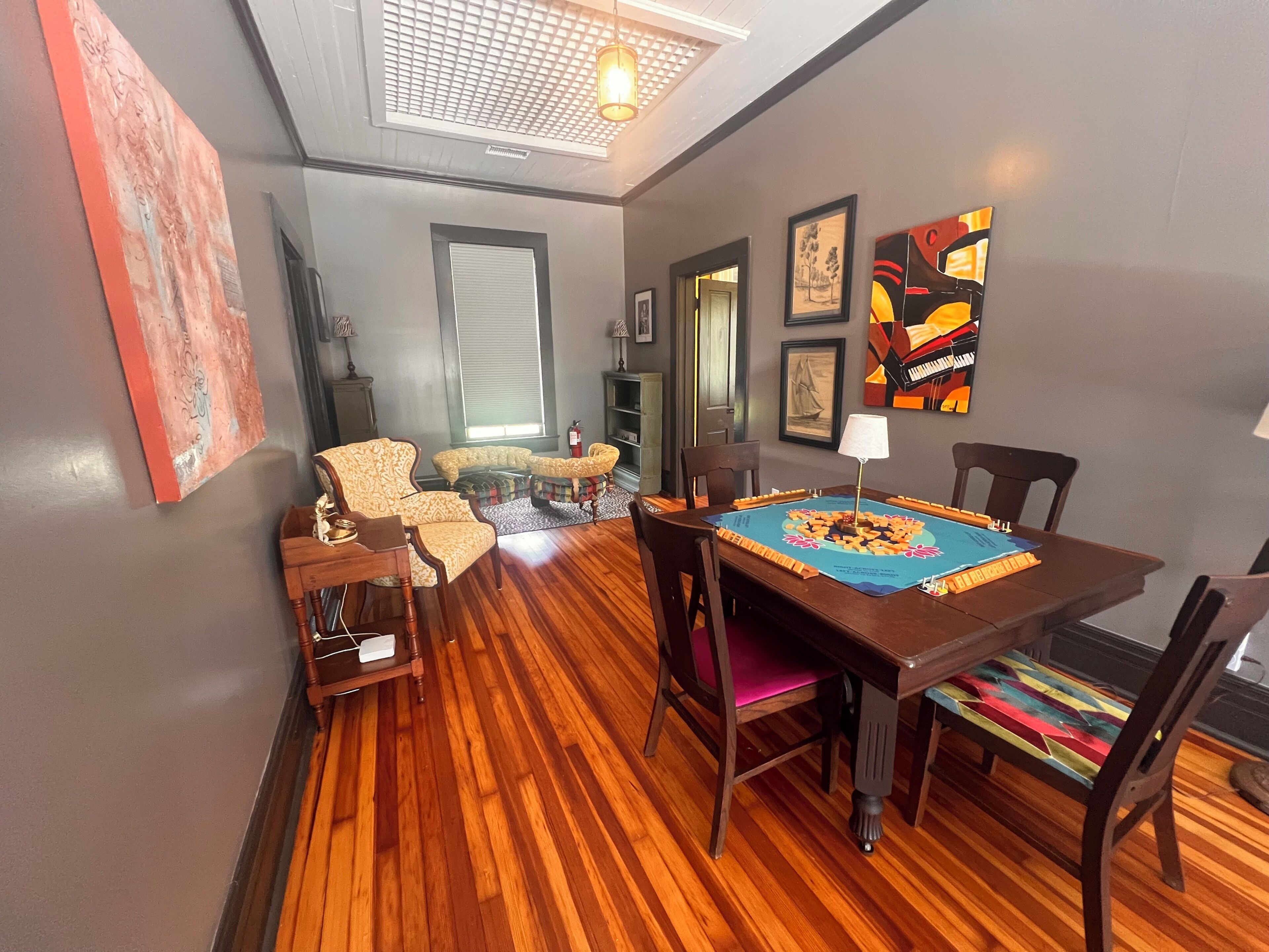 Uma área de refeições com mesa de madeira, cadeiras e um jogo americano azul.