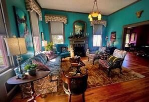 A living room with a fireplace, a sofa set, a coffee table, and a dining table.