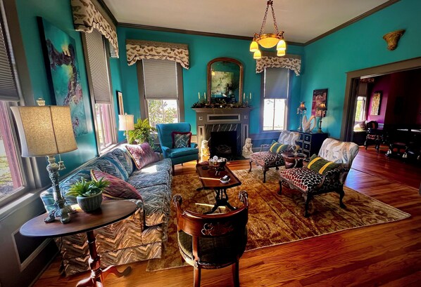 A living room with a fireplace, a sofa set, a coffee table, and a dining table.