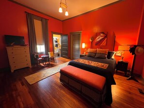 A bedroom with a bed, dresser, and a television.