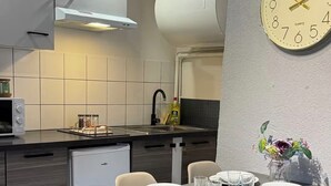 Una cocina moderna con comedor, que incluye un reloj en la pared.