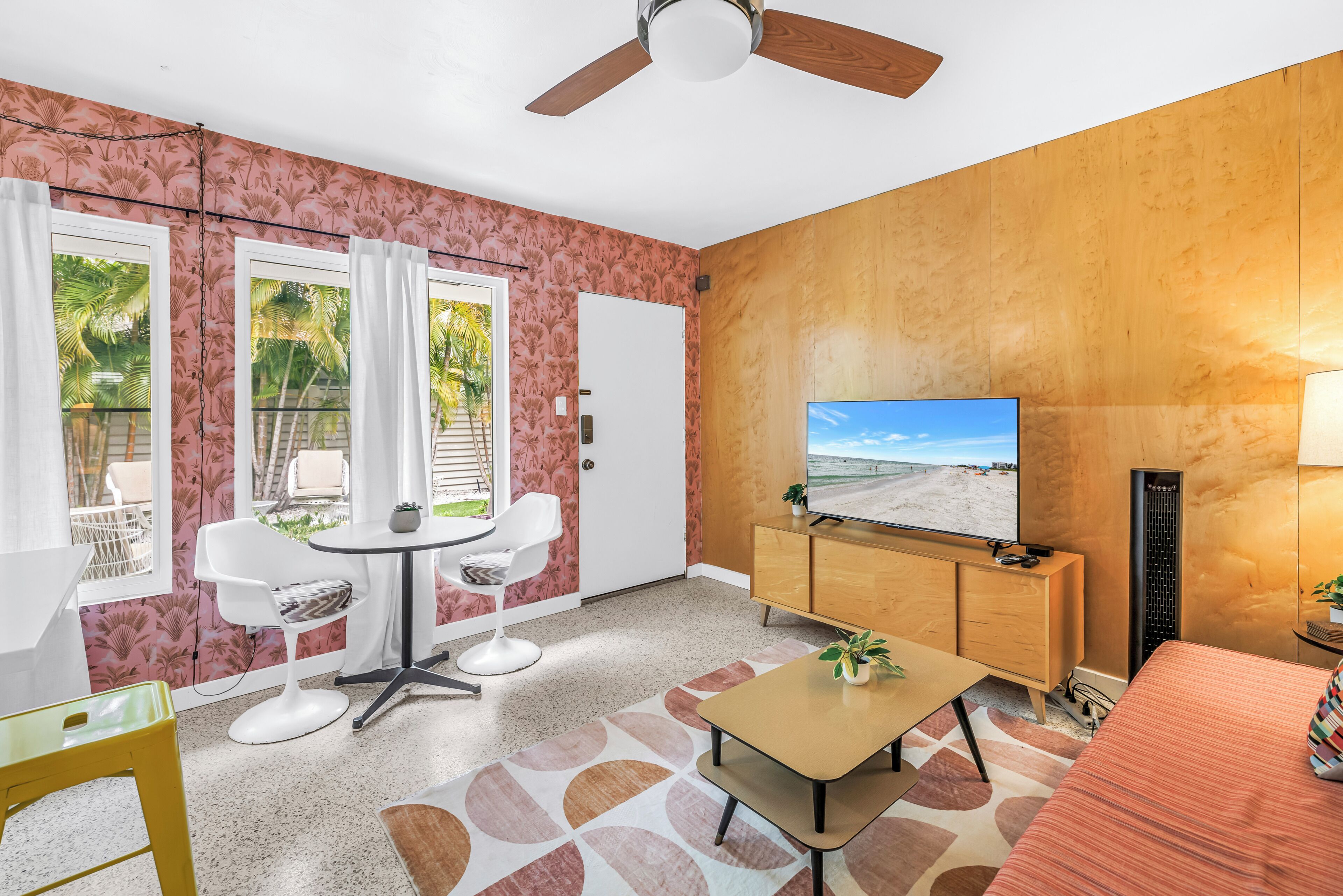 Uma sala de estar moderna com televisão, área de estar e vista para o exterior.