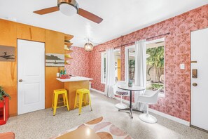 A modern kitchen with a wooden cabinet, a white countertop, and a ceiling fan. - Sunny Lido Beach Studio (Sarasota)