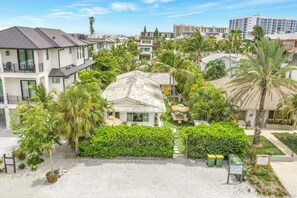 A residential area with multiple two-story houses, a central building with a tiled roof, and surrounding greenery including palm trees. - Sunny Lido Beach Studio (Sarasota)