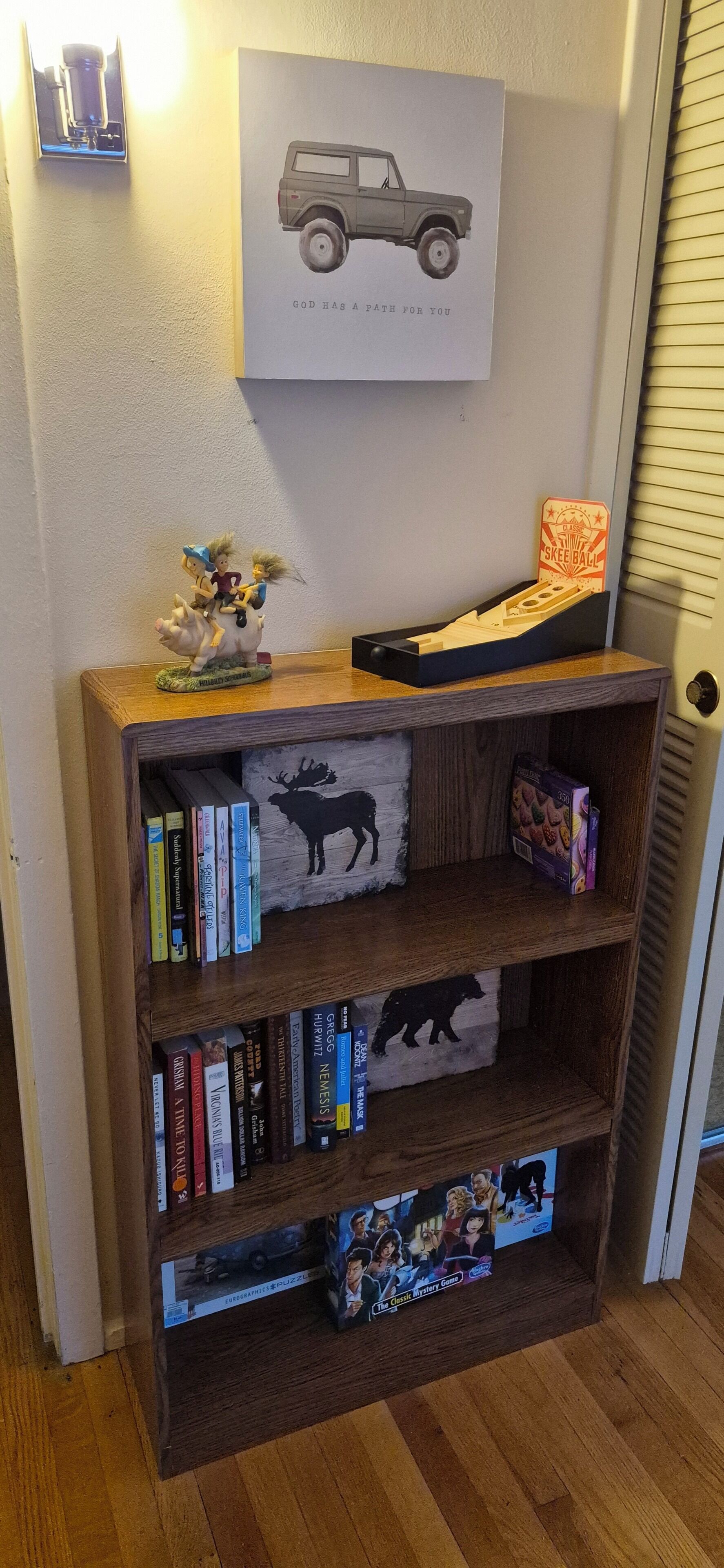 A wooden bookshelf with books and decorative items.
