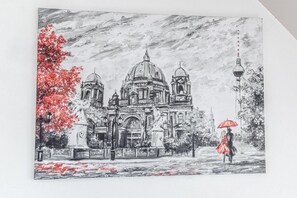 Dibujo arquitectónico monocromático de un edificio con cúpulas y una estatua, un árbol con hojas rojas y una persona con un paraguas.