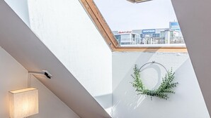 A skylight with a view of a building labeled 'DECOTHON' and a wreath on the wall.